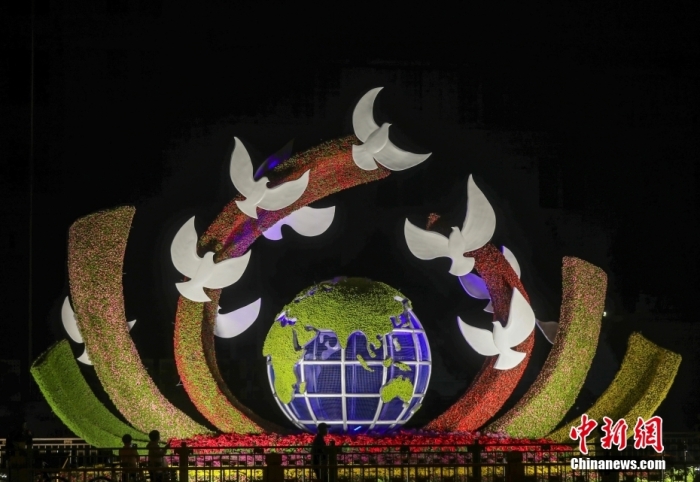 资料图：2022年9月26日晚，北京长安街沿线国庆主题花坛亮灯，市民在参观军事博物馆前广场布置的“命运共同体”花坛。 <a target='_blank' href='/'>中新社</a>记者 易海菲 摄