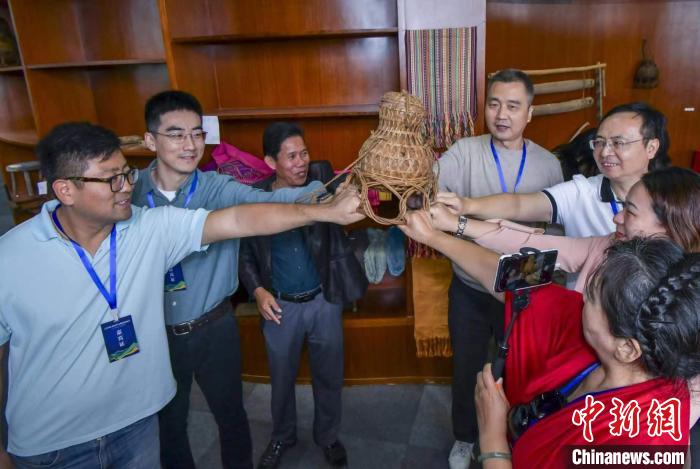 11月1日，符进平向海外华文媒体人士介绍黎族渡水葫芦。　骆云飞 摄